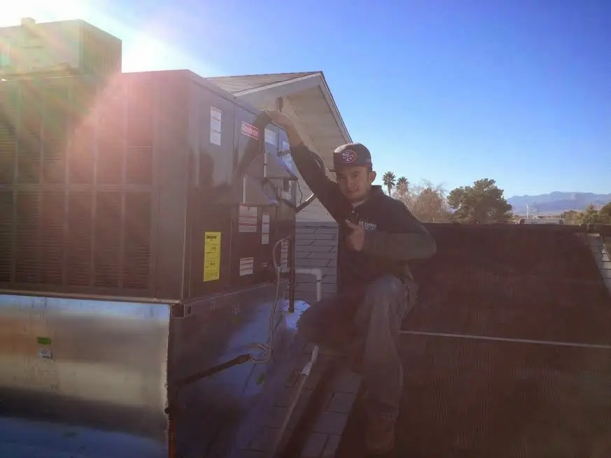 HVAC technician performing AC Tune-Up on a rooftop unit in Richmond West